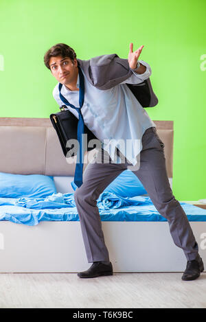 The employee in the bedroom being late for his job Stock Photo