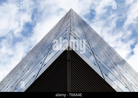 Glass architecture. Photo from the bottom of the modern facade of an office building. Sample of a dynamic business cityscape. Abstract high-tech composition with glazing. Stock Photo