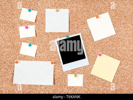 Blank paper notes and a photo pinned to a corkboard. Stock Photo