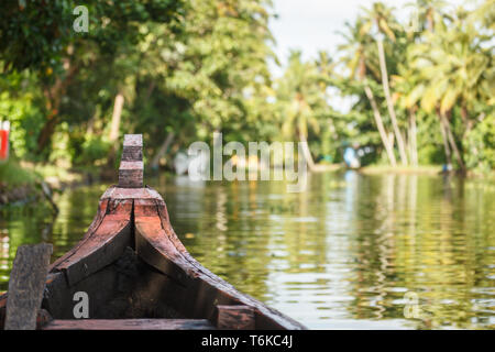 Closeup view of prow of dugout canoe riding down river in jungle in India Stock Photo