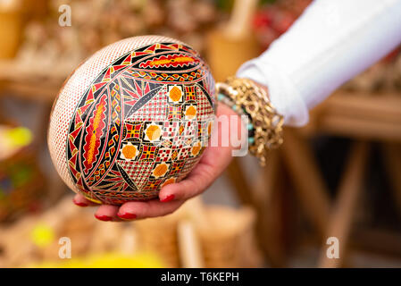 Big wooden painted egg in a hand Stock Photo