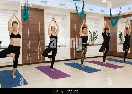group of womans doing yoga exercises in gym. Fit and wellness lifestyle. Stock Photo