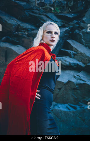 Angled view of woman wearing cape and mask Stock Photo