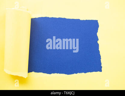 Torn yellow paper isolated on blue Stock Photo