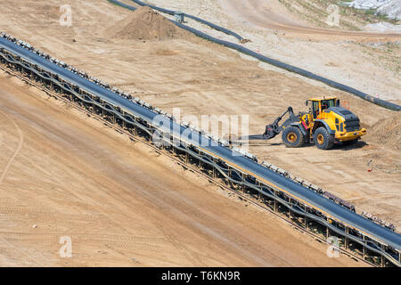 Brown coal open pit landscape with conveyor belt and dozer
