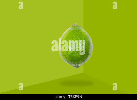 Fresh lime levitate in air on green background. Concept of fruit levitation. Stock Photo