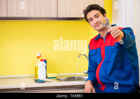Plumber repairing tap at kitchen Stock Photo
