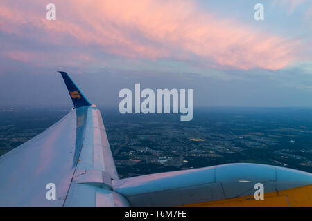 Dulles, USA - June 13, 2018: Icelandair airplane in sky from window high angle view over Atlantic Arctic ocean during sunset plane wing by airport in  Stock Photo