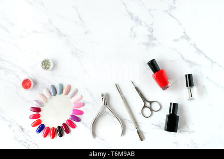 Set of various manicure and pedicure tools and accessories on white marble background. Top view. Stock Photo