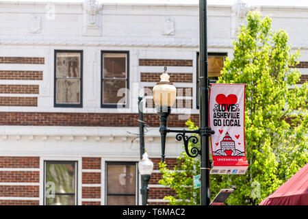 Asheville, USA - April 19, 2018: Downtown old town street in North Carolina NC city with sign for local love banner on lamp post Stock Photo