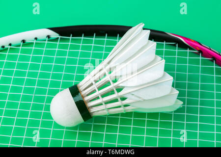 Badminton shuttlecock and racket on green background Stock Photo