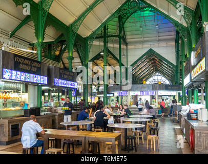 green painted cast iron latticework, and diners seated at tables Lau Pa Sat Hawker Food markets in downtown Singapore. Stock Photo