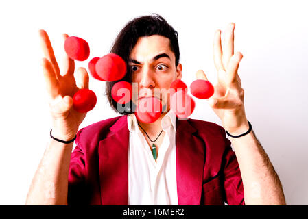 Young magician throwing red air balls to look for luck. Stock Photo