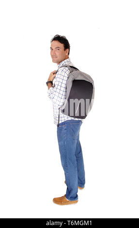 Young man standing in profile with his backpack Stock Photo