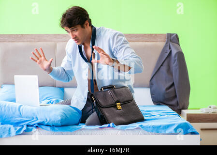 Employee in the bedroom being late for his job Stock Photo