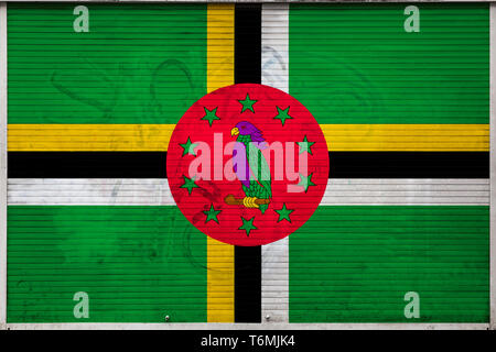 Close-up of old metal wall with national flag of Dominica. Concept of Dominica export-import, storage of goods and national delivery of goods. Flag in Stock Photo