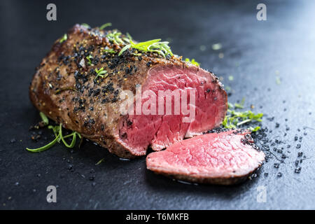 Traditional barbecue dry aged wagyu fillet steak with herb and spice marinated as closeup on a black board Stock Photo