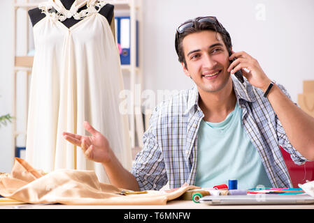 Young handsome tailor working in his workshop Stock Photo