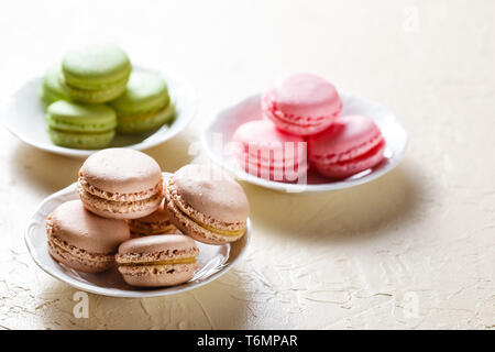 Colourful macaroons on the plates Stock Photo