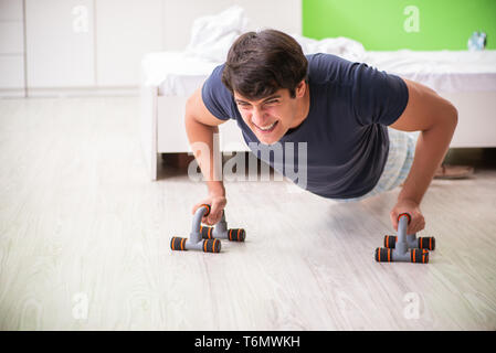 Young man in pajamas doing morning exercises Stock Photo