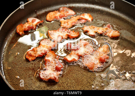 Fatty Bacon Frying in a Pan Stock Photo