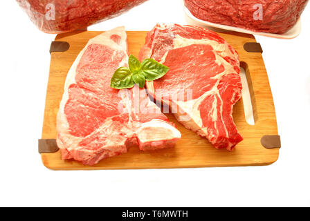 Close-Up of Two Beef Steaks with Fresh Basil Stock Photo