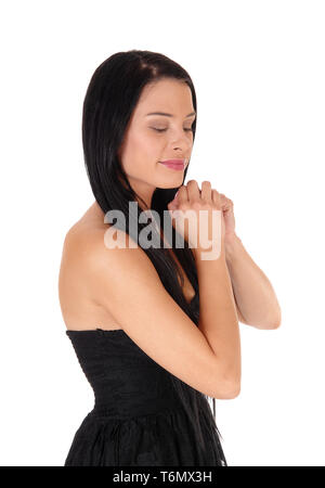 Profile of young woman praying with hands folded Stock Photo