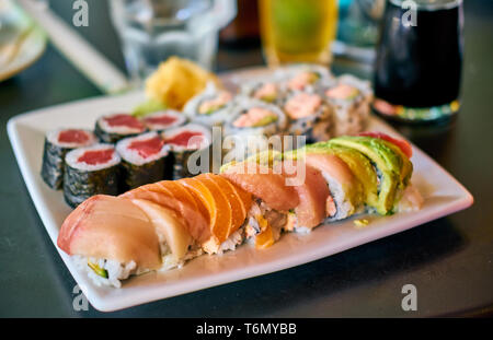Rainbow sushi roll on table in restaurant Stock Photo