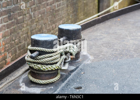 Rope tied to steel bollard on ship deck Stock Photo