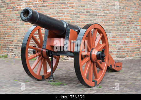 Old medieval artillery canon before a brick wall Stock Photo