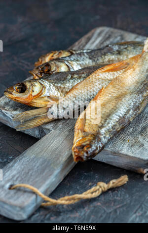 Dry salted fish on a wooden board. Stock Photo