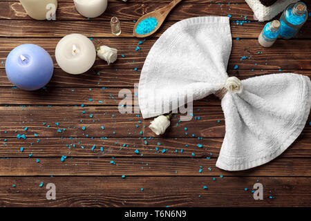 Beautiful spa composition with candles, sea salt and towel on wooden background, top view Stock Photo