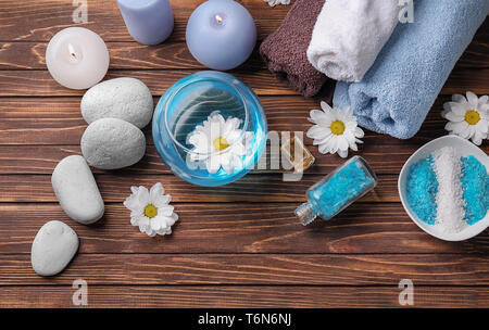 Beautiful spa composition with sea salt, towels and candles on wooden background, top view Stock Photo