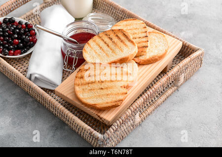 Tray with toasted bread and jam on grey background Stock Photo