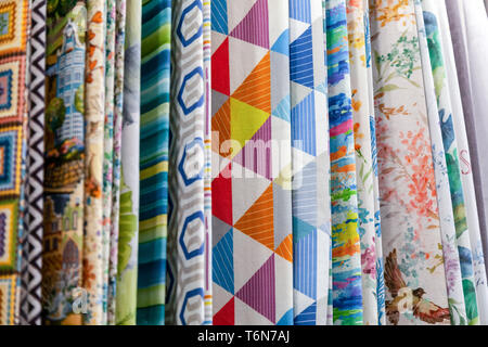 Close-up rows of pieces of fabric made of cotton, polyester, tapestry and other materials of different colors and prints for sewing curtains, bedding  Stock Photo