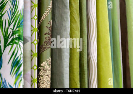 Close-up rows of pieces of fabric made of cotton, polyester, tapestry and other materials of different colors and prints for sewing curtains, bedding  Stock Photo
