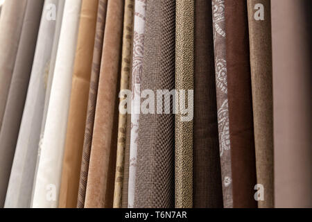 Close-up rows of pieces of fabric made of cotton, polyester, tapestry and other materials of different colors and prints for sewing curtains, bedding  Stock Photo