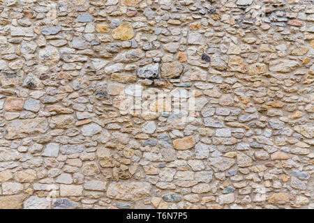 Rough, highly textured old stone block wall Stock Photo