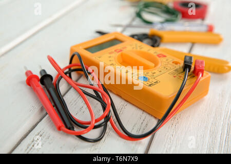 Multimeter on wooden table. Electrical tools Stock Photo