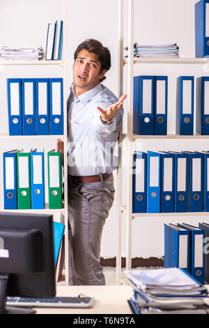 The young male employee working in the office Stock Photo