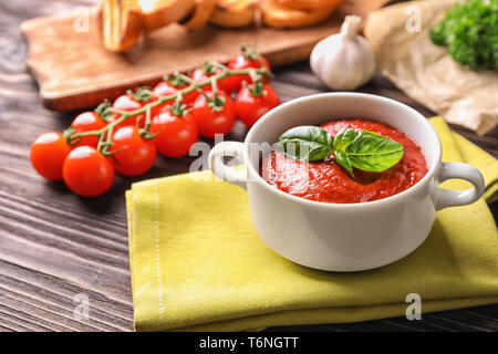 Tureen with tasty tomato sauce on wooden table Stock Photo