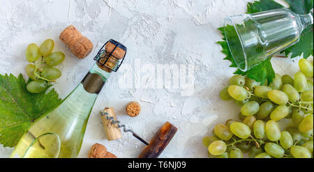 Bottle of white wine, grapes, glass and corkscrew. Stock Photo