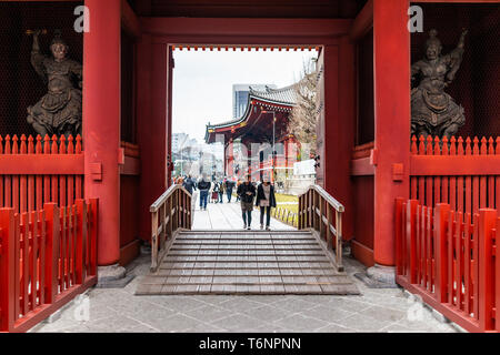 Tokyo, Japan - March 30, 2018: Asakusa district area with entrance to Sensoji temple shrine with red architecture and people walking under gate Stock Photo