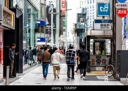 Tokyo, Japan - March 31, 201: Ginza district with people walking on sidewalk by metro station entrance Stock Photo