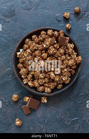 Caramel chocolate popcorn on a wooden platter. Stock Photo