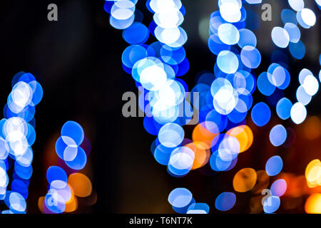 Round bokeh abstract background with blue neon circles illuminated decoration lights on tree at night evening dark black christmas in Shinjuku, Tokyo Stock Photo