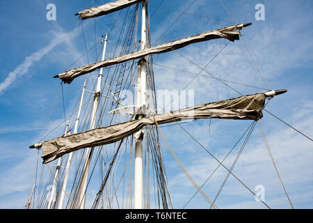 Masts and rigging of a big old sailing ship in front of a blue sky ...