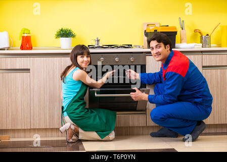 Woman with contractor at kitchen discussing repair Stock Photo