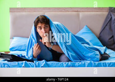 Employee in the bedroom being late for his job Stock Photo