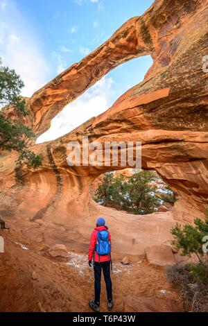 Hiker in front of Double O Arch, rock arch, Devil's Garden Trail, Arches National Park, near Moab, Utah, USA Stock Photo